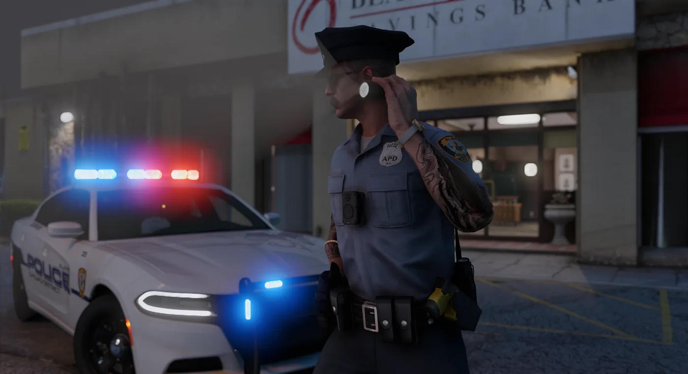 An Alamo Police officer on patrol at night beside a patrol car